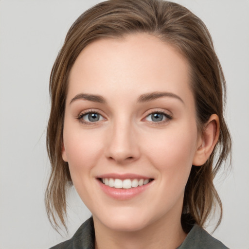 Joyful white young-adult female with medium  brown hair and grey eyes