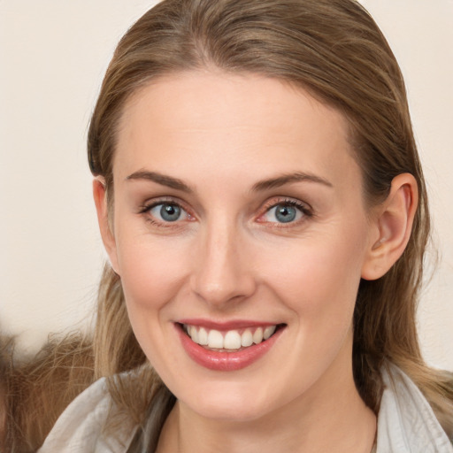 Joyful white young-adult female with long  brown hair and blue eyes