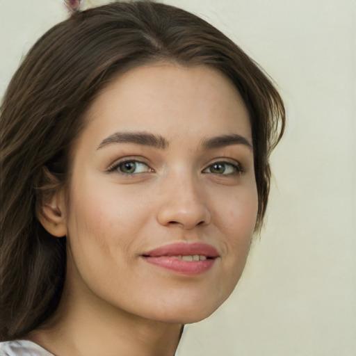 Joyful white young-adult female with long  brown hair and green eyes