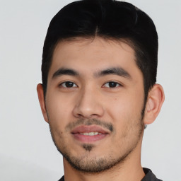 Joyful latino young-adult male with short  black hair and brown eyes