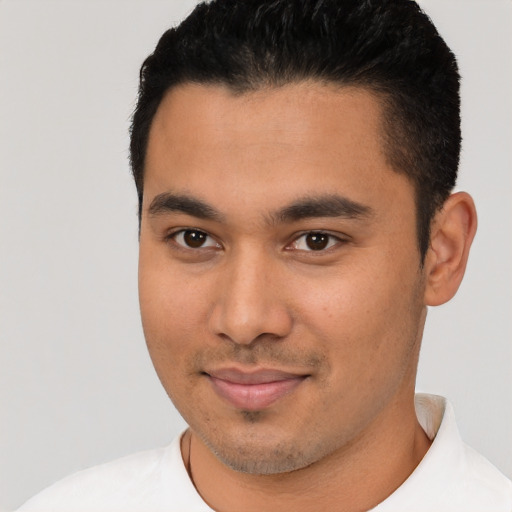 Joyful latino young-adult male with short  black hair and brown eyes