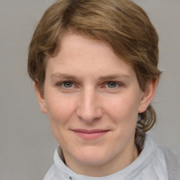 Joyful white young-adult female with medium  brown hair and blue eyes