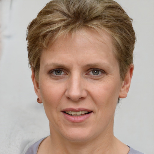 Joyful white adult female with short  brown hair and grey eyes