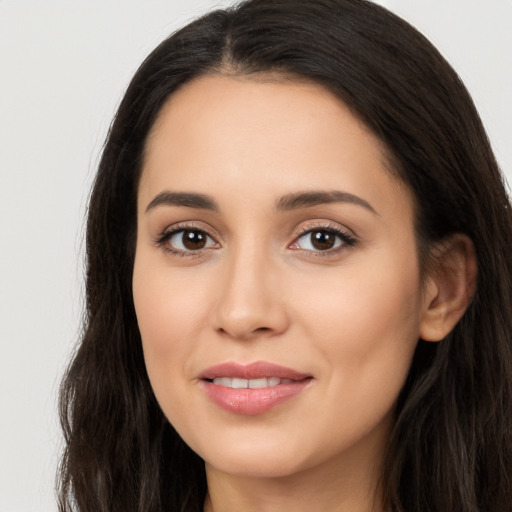 Joyful latino young-adult female with long  brown hair and brown eyes