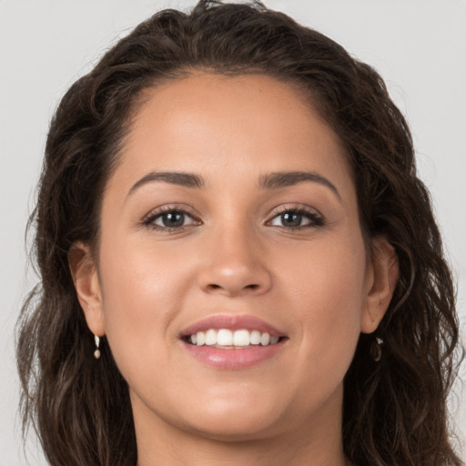 Joyful white young-adult female with long  brown hair and brown eyes