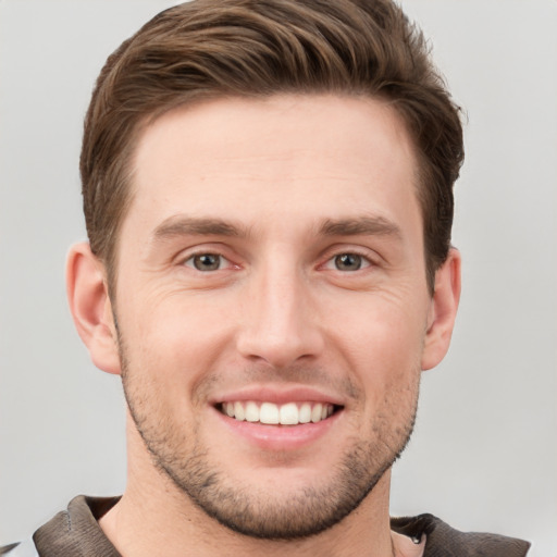 Joyful white young-adult male with short  brown hair and grey eyes