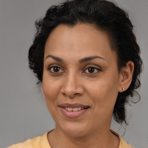 Joyful latino adult female with medium  brown hair and brown eyes