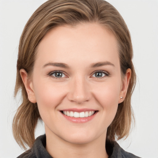 Joyful white young-adult female with medium  brown hair and grey eyes