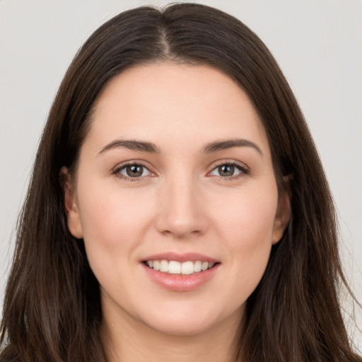 Joyful white young-adult female with long  brown hair and brown eyes