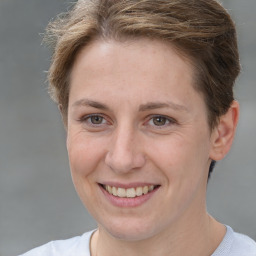 Joyful white young-adult female with short  brown hair and grey eyes