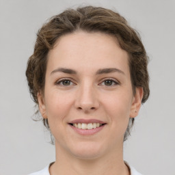 Joyful white young-adult female with medium  brown hair and grey eyes