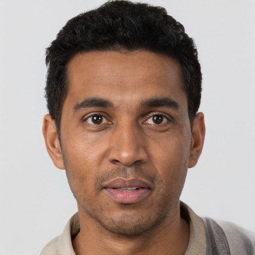 Joyful black young-adult male with short  black hair and brown eyes