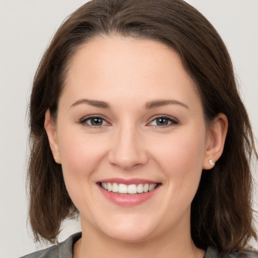 Joyful white young-adult female with medium  brown hair and grey eyes