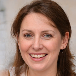 Joyful white adult female with medium  brown hair and grey eyes