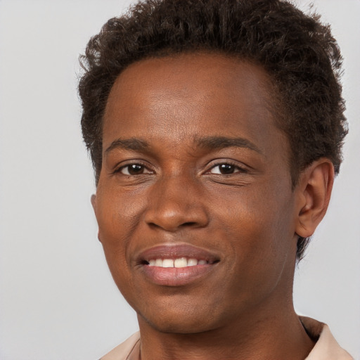 Joyful black young-adult male with short  brown hair and brown eyes