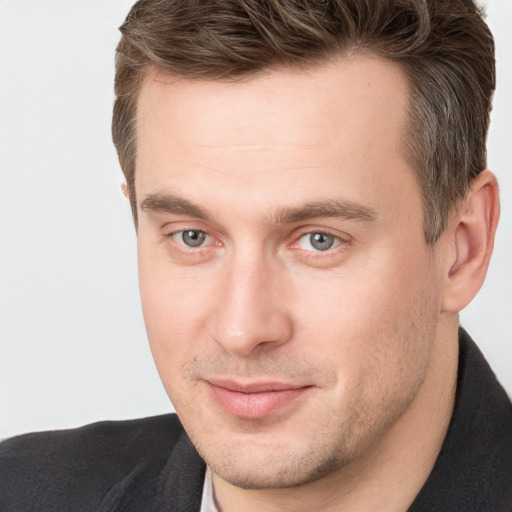 Joyful white young-adult male with short  brown hair and grey eyes