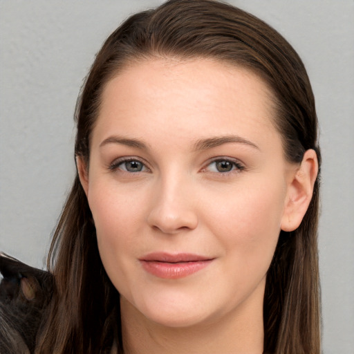 Joyful white young-adult female with long  brown hair and brown eyes