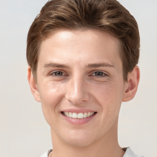 Joyful white young-adult female with short  brown hair and grey eyes