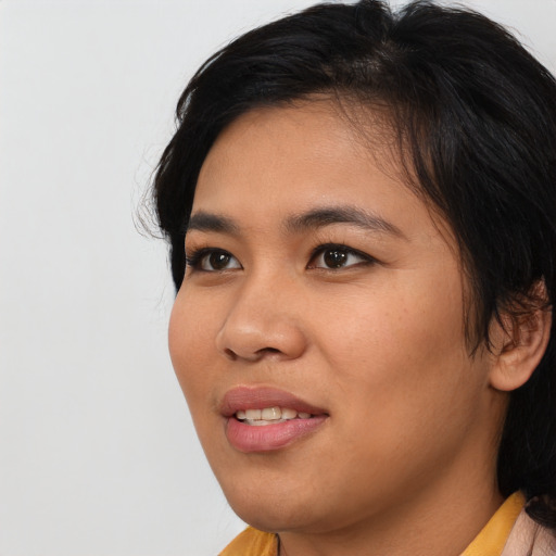 Joyful asian young-adult female with medium  black hair and brown eyes