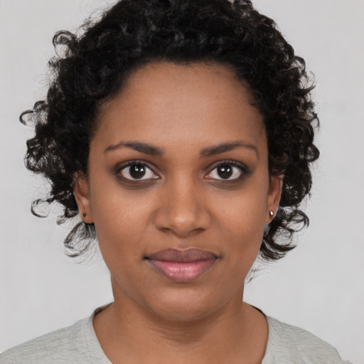 Joyful black young-adult female with short  black hair and brown eyes
