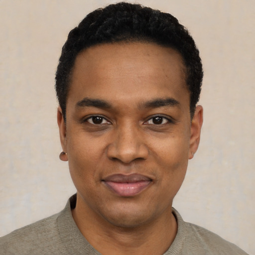 Joyful black young-adult male with short  black hair and brown eyes