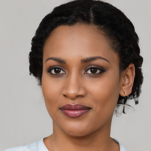 Joyful black young-adult female with long  black hair and brown eyes