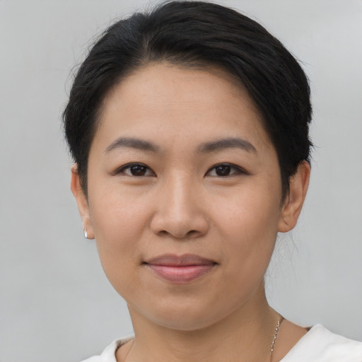 Joyful asian young-adult female with short  black hair and brown eyes
