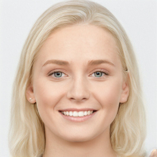 Joyful white young-adult female with long  blond hair and blue eyes