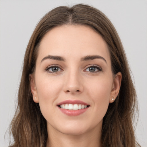 Joyful white young-adult female with long  brown hair and grey eyes