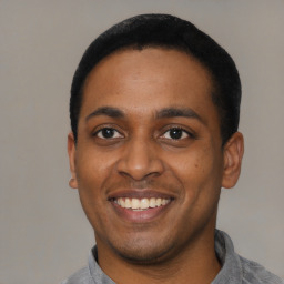 Joyful latino young-adult male with short  black hair and brown eyes