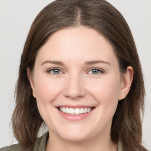 Joyful white young-adult female with medium  brown hair and grey eyes