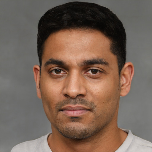 Joyful latino young-adult male with short  black hair and brown eyes