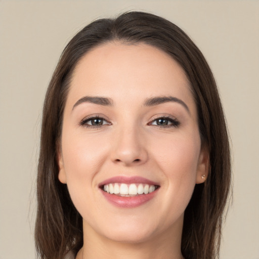 Joyful white young-adult female with long  brown hair and brown eyes