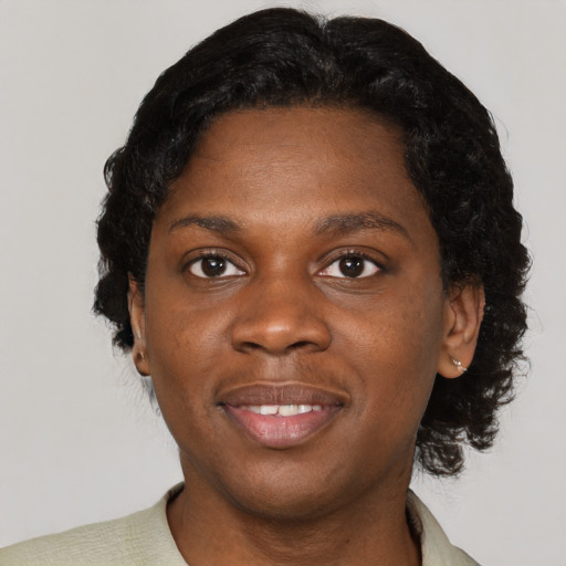 Joyful black young-adult female with short  black hair and brown eyes