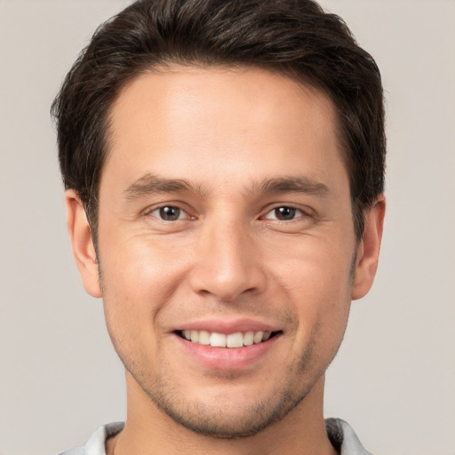 Joyful white young-adult male with short  brown hair and brown eyes