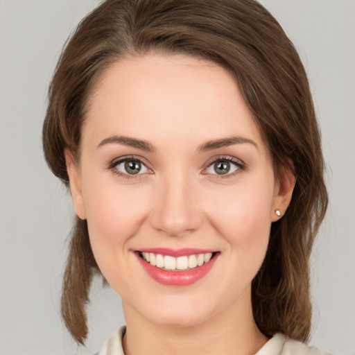 Joyful white young-adult female with medium  brown hair and green eyes