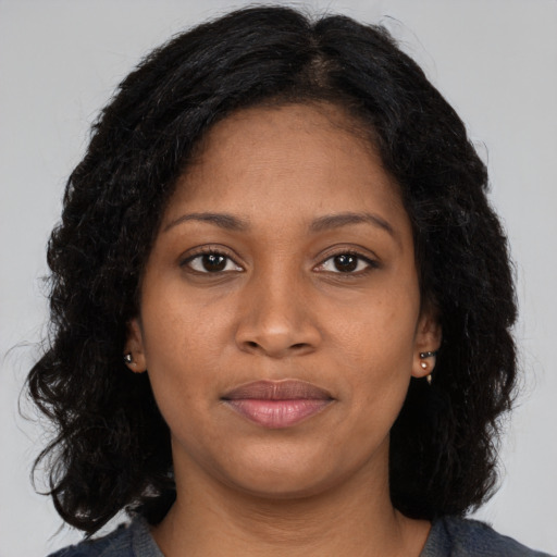 Joyful black young-adult female with long  brown hair and brown eyes