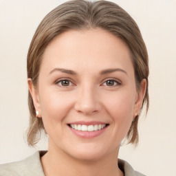 Joyful white young-adult female with medium  brown hair and grey eyes