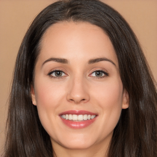 Joyful white young-adult female with long  brown hair and brown eyes