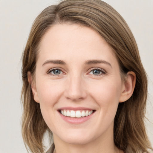 Joyful white young-adult female with long  brown hair and green eyes