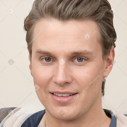 Joyful white young-adult male with short  brown hair and grey eyes