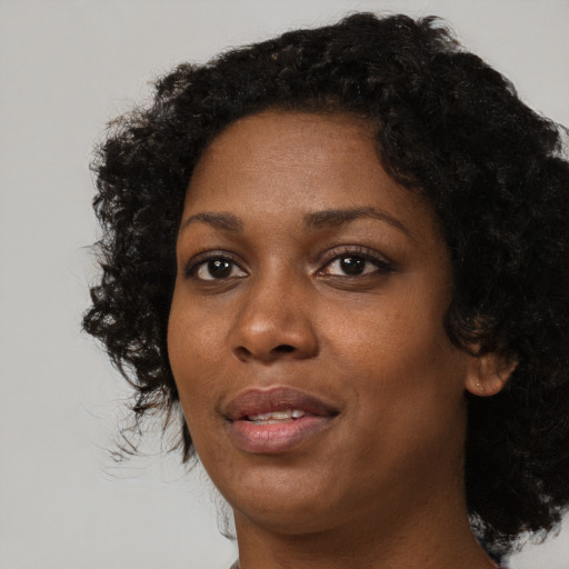 Joyful black adult female with medium  black hair and brown eyes