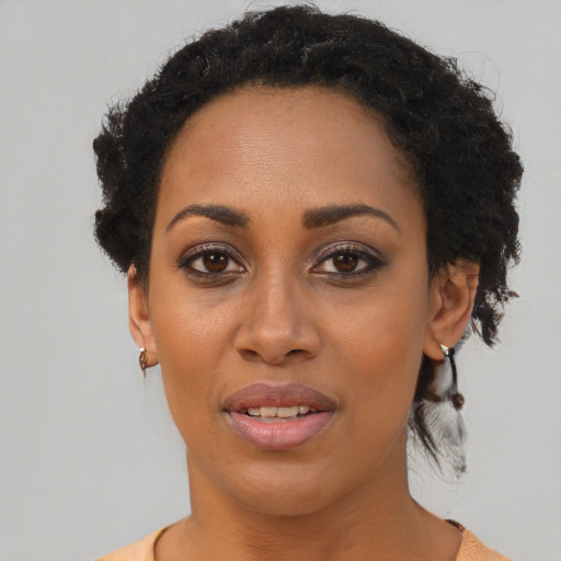 Joyful black young-adult female with short  black hair and brown eyes