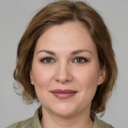 Joyful white young-adult female with medium  brown hair and grey eyes