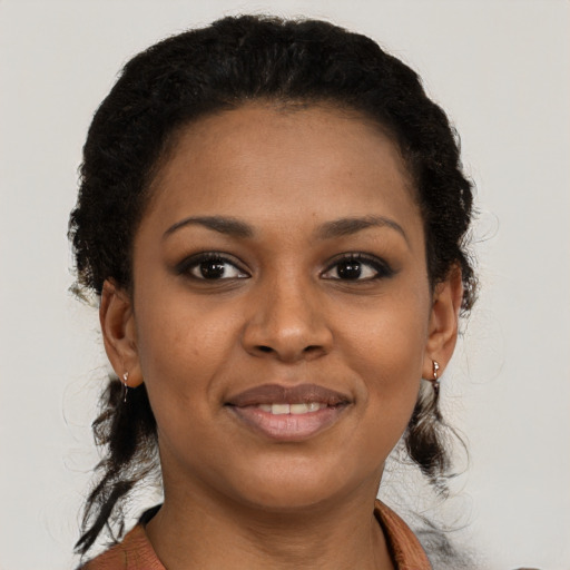 Joyful black young-adult female with short  brown hair and brown eyes