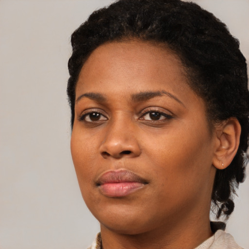 Joyful black young-adult female with medium  black hair and brown eyes