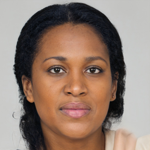 Joyful black young-adult female with long  brown hair and brown eyes