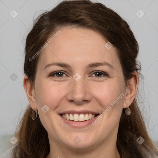 Joyful white adult female with long  brown hair and brown eyes