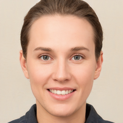 Joyful white young-adult female with short  brown hair and grey eyes