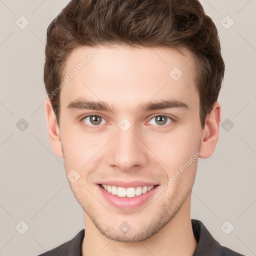 Joyful white young-adult male with short  brown hair and grey eyes